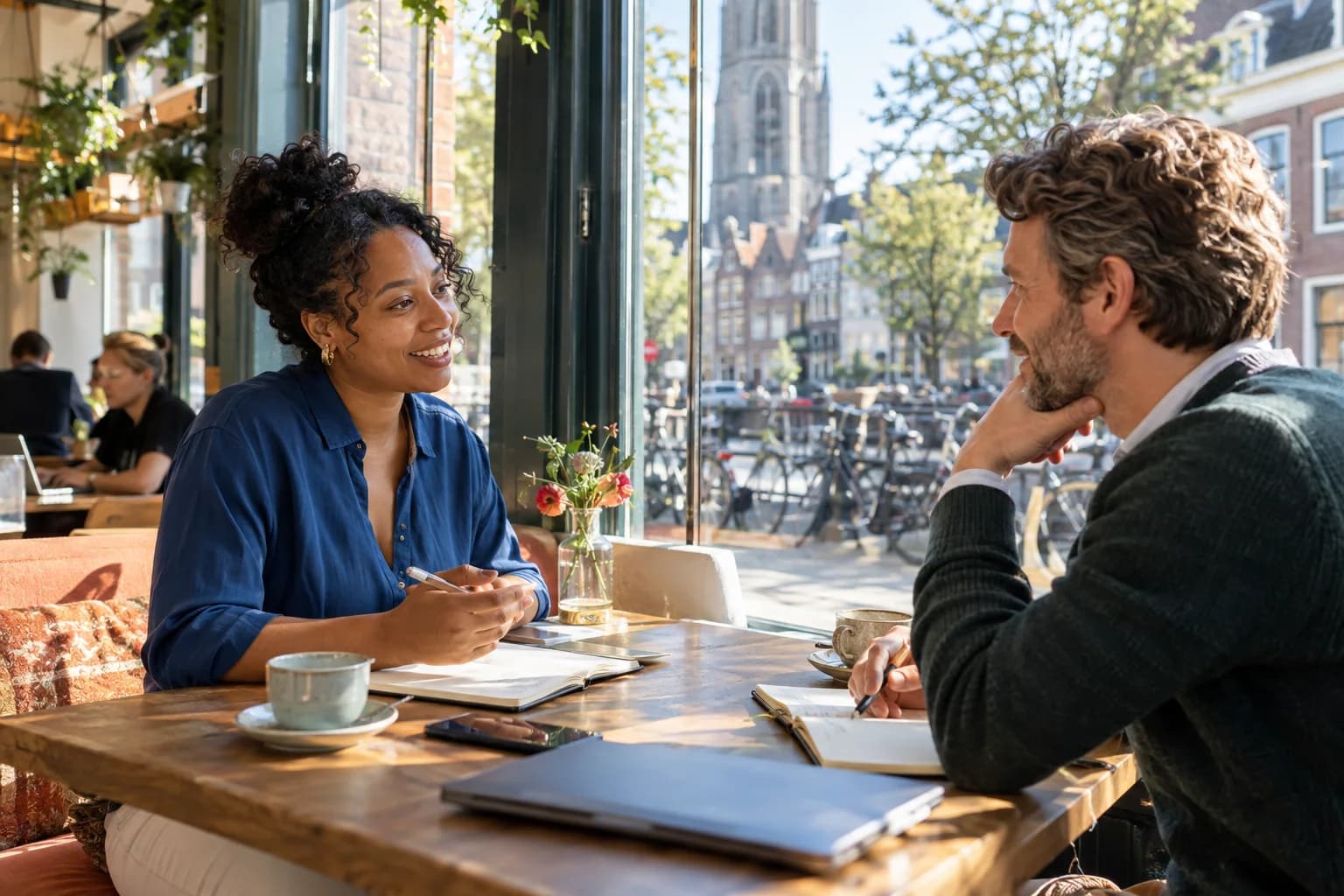 Kandidaat en recruiter in een open gesprek in een zonnige Nederlandse stad